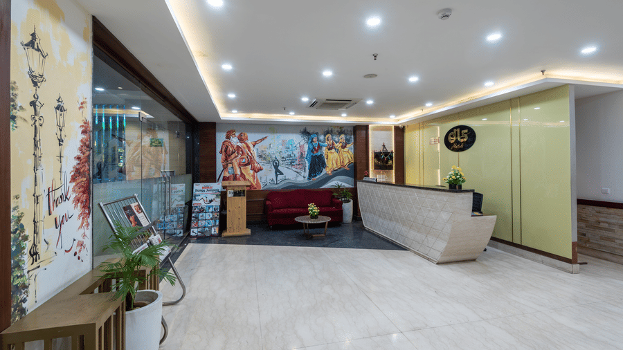 Reception area with a newspaper stand, spiritual wall paintings, and a front desk at DLS The Classio